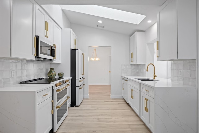 25451 Kowloon Ln, Punta Gorda, FL 33983 - kitchen featuring white appliances, vaulted ceiling, a skylight, tasteful backsplash, and light wood-style floors