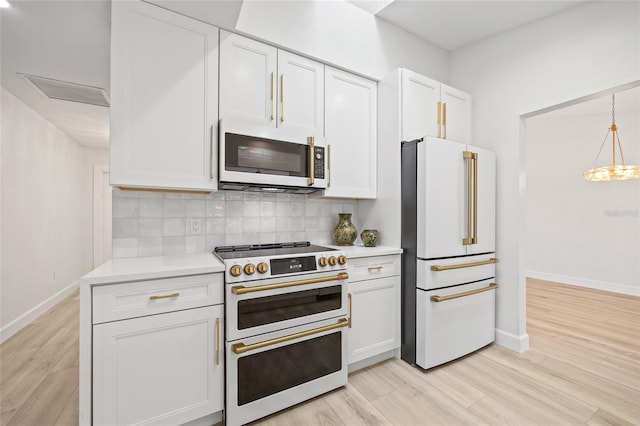 25451 Kowloon Ln, Punta Gorda, FL 33983 - kitchen with white appliances, light countertops, backsplash, light wood-style flooring, and white cabinetry