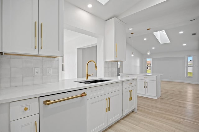 25451 Kowloon Ln, Punta Gorda, FL 33983 - kitchen featuring a skylight, dishwasher, white cabinetry, decorative backsplash, and light wood finished floors
