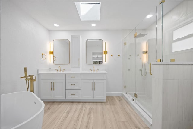 25451 Kowloon Ln, Punta Gorda, FL 33983 - bathroom featuring a stall shower, a freestanding bath, double vanity, wood finished floors, and a skylight