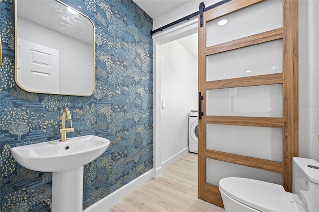 25451 Kowloon Ln, Punta Gorda, FL 33983 - bathroom featuring wood finished floors, wallpapered walls, and washer / clothes dryer