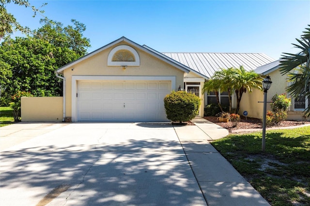 27102 Harbour Oaks Blvd, Punta Gorda, FL 33983 - view of front of house with stucco siding, driveway, an attached garage, and a metal roof
