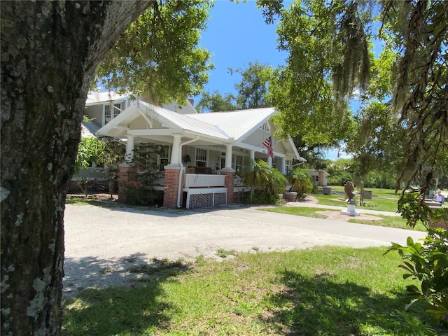 606 E Oak St, Arcadia, FL 34266 - view of home's exterior featuring covered porch, a yard, and a metal roof