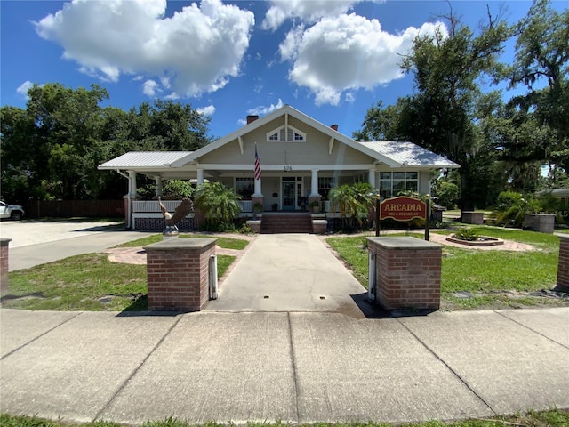 606 E Oak St, Arcadia, FL 34266 - view of front of home featuring covered porch, a metal roof, a front lawn, and driveway