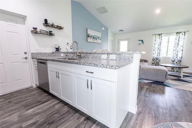 1710 Blackwood Cir, North Port, FL 34288 - kitchen with stainless steel dishwasher, a peninsula, lofted ceiling, dark wood finished floors, and white cabinetry