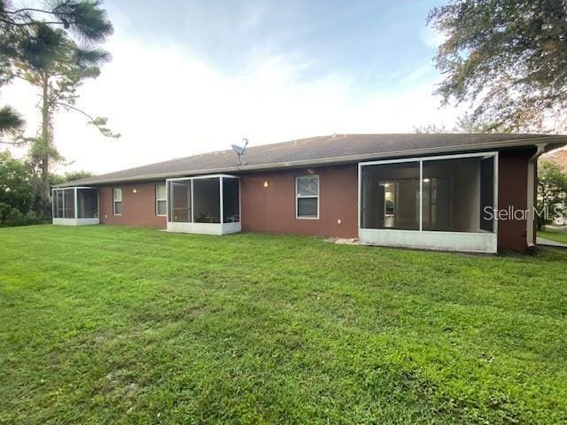 1491 Capricorn Blvd, Punta Gorda, FL 33983 - back of house with a sunroom, a yard, and stucco siding