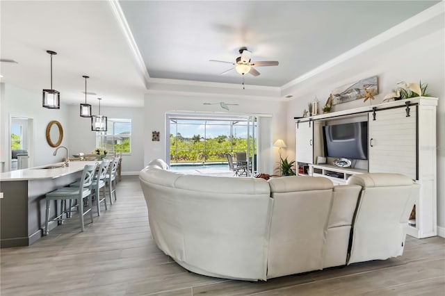 13416 Trascoro Ln, Port Charlotte, FL 33981 - living area featuring a tray ceiling, a ceiling fan, crown molding, and light wood-style flooring