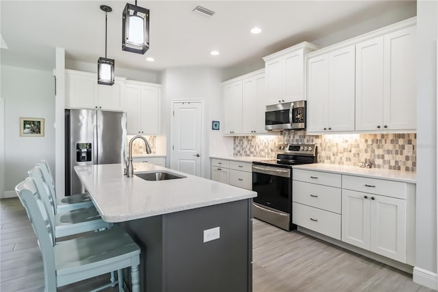 13416 Trascoro Ln, Port Charlotte, FL 33981 - kitchen featuring appliances with stainless steel finishes, light wood finished floors, a breakfast bar, recessed lighting, and decorative backsplash
