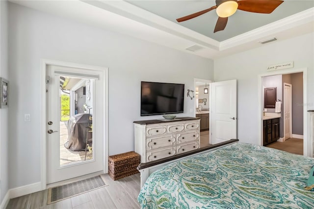 13416 Trascoro Ln, Port Charlotte, FL 33981 - bedroom featuring light wood finished floors, a raised ceiling, ensuite bath, and ceiling fan