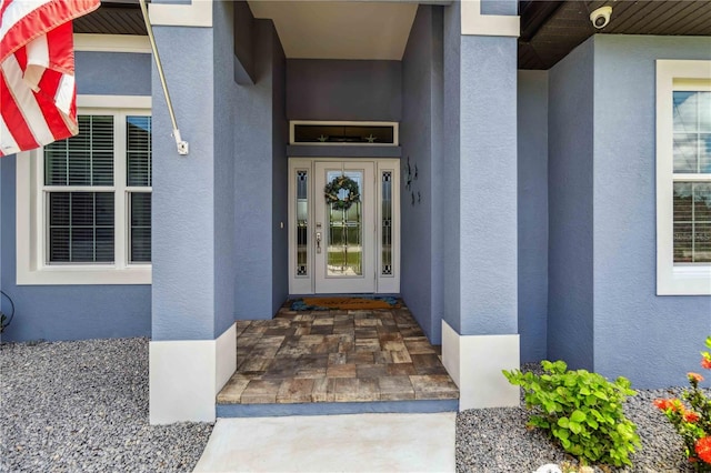 13416 Trascoro Ln, Port Charlotte, FL 33981 - property entrance with stucco siding and a surveillance system