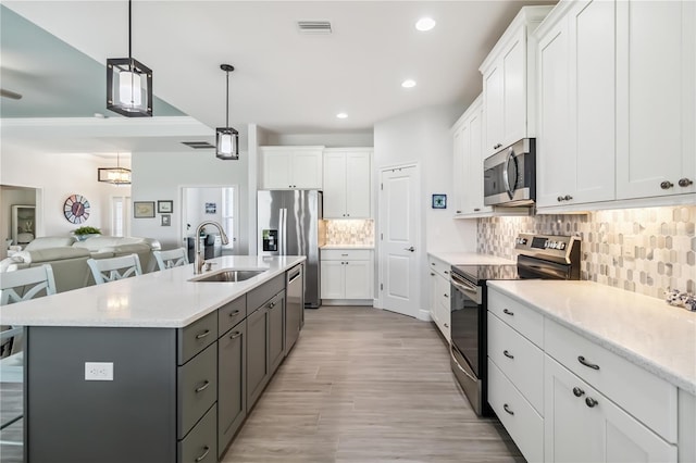 13416 Trascoro Ln, Port Charlotte, FL 33981 - kitchen featuring stainless steel appliances, white cabinets, backsplash, open floor plan, and recessed lighting