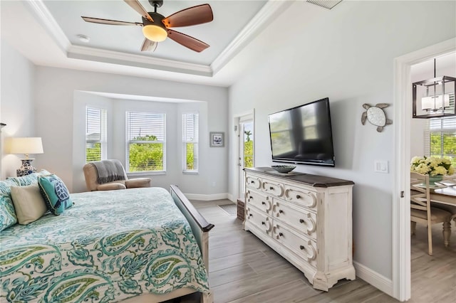 13416 Trascoro Ln, Port Charlotte, FL 33981 - bedroom featuring a raised ceiling, light wood finished floors, crown molding, a ceiling fan, and access to exterior