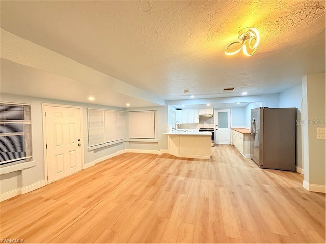 3902 Locust Ave, Sarasota, FL 34234 - unfurnished living room featuring light wood-style flooring and a textured ceiling