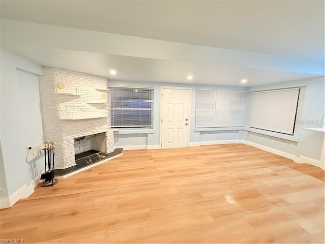 3902 Locust Ave, Sarasota, FL 34234 - unfurnished living room with light wood finished floors, a stone fireplace, and recessed lighting