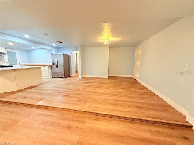 3902 Locust Ave, Sarasota, FL 34234 - unfurnished living room featuring light wood-style floors, arched walkways, and recessed lighting