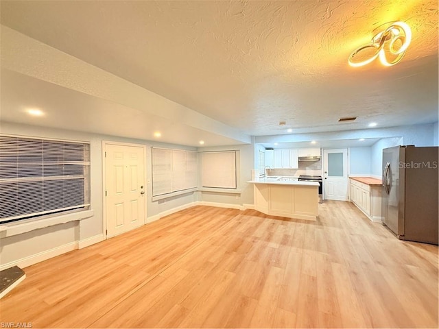 3902 Locust Ave, Sarasota, FL 34234 - unfurnished living room featuring light wood-style floors, a textured ceiling, and recessed lighting