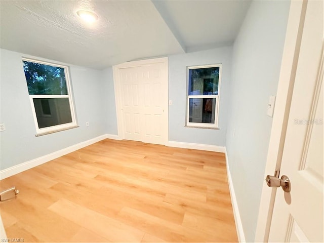 3902 Locust Ave, Sarasota, FL 34234 - unfurnished bedroom featuring light wood finished floors, a closet, and a textured ceiling