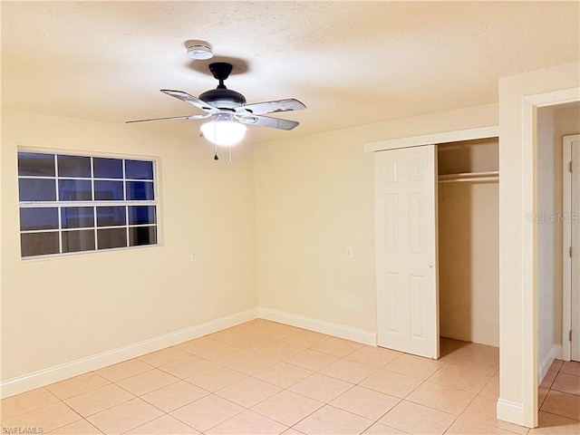 3902 Locust Ave, Sarasota, FL 34234 - unfurnished bedroom with light tile patterned flooring, a closet, and a ceiling fan