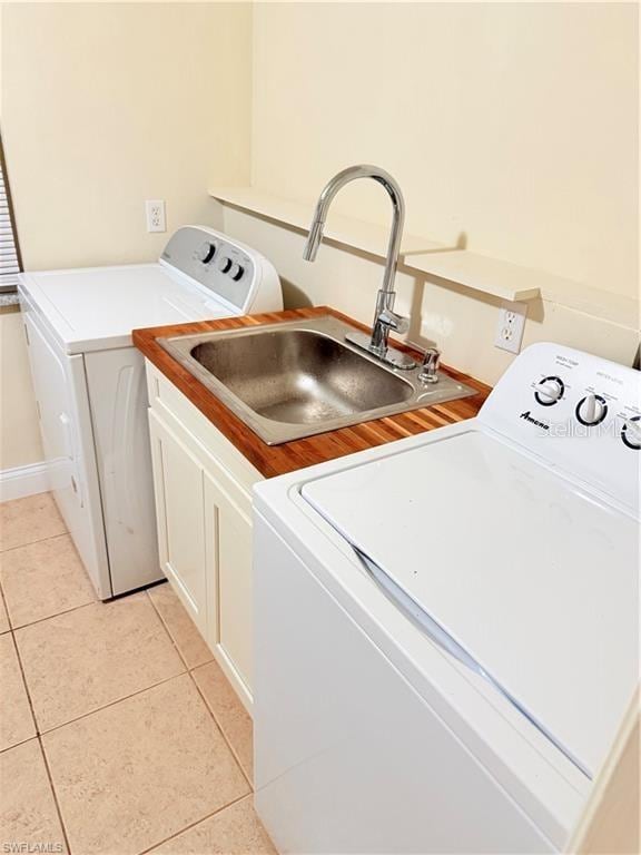 3902 Locust Ave, Sarasota, FL 34234 - washroom with cabinet space, washer and clothes dryer, and light tile patterned flooring