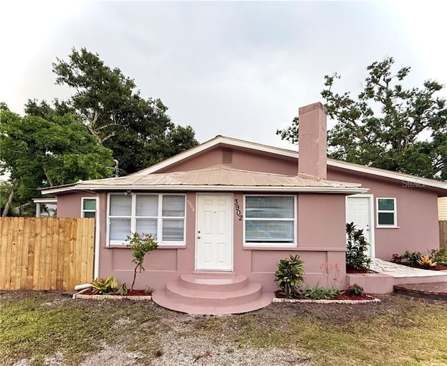 3902 Locust Ave, Sarasota, FL 34234 - view of front of home featuring stucco siding, a chimney, and a metal roof