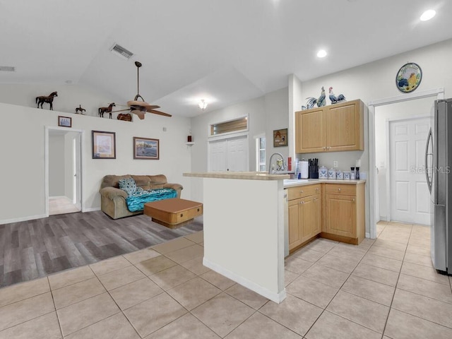 9761 Councilor Ln, North Fort Myers, FL 33917 - kitchen with open floor plan, light tile patterned floors, stainless steel fridge, a peninsula, and lofted ceiling