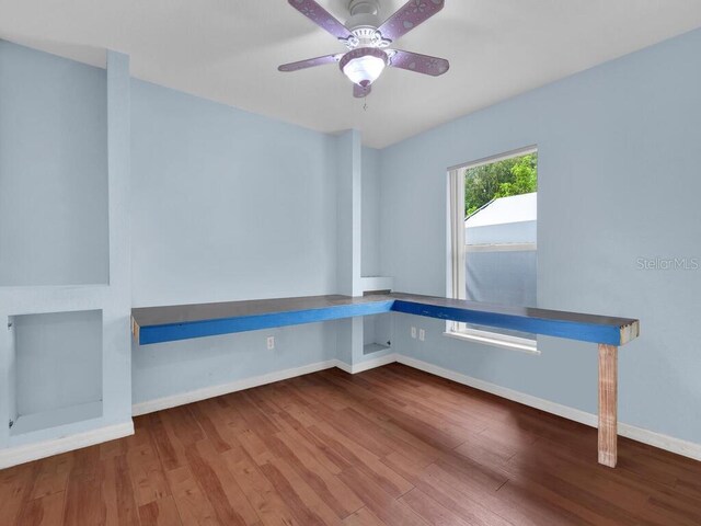 9761 Councilor Ln, North Fort Myers, FL 33917 - unfurnished office featuring wood finished floors, ceiling fan, and built in desk