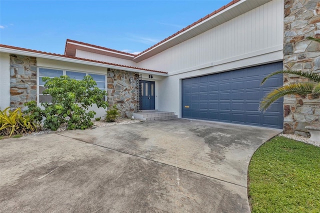 16 Tropicana Dr, Punta Gorda, FL 33950 - mediterranean / spanish home with stone siding, a tile roof, concrete driveway, and an attached garage