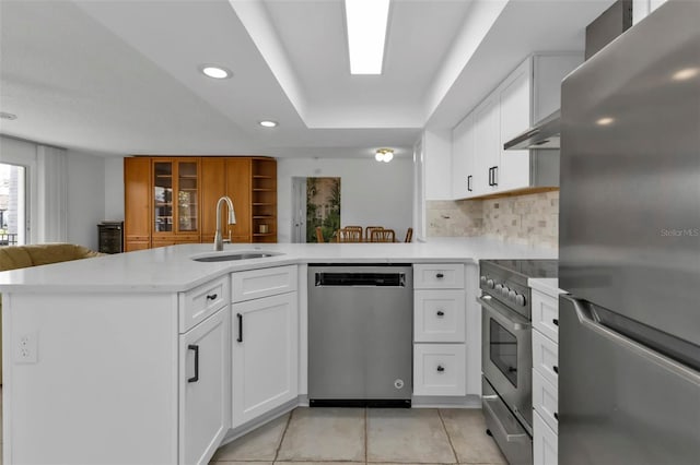 16 Tropicana Dr, Punta Gorda, FL 33950 - kitchen with appliances with stainless steel finishes, a peninsula, white cabinets, light tile patterned floors, and recessed lighting