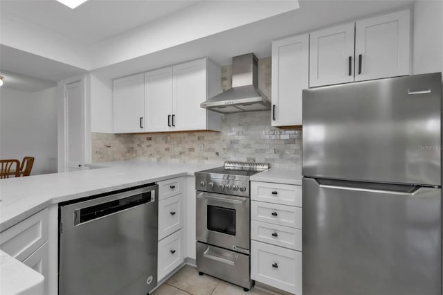 16 Tropicana Dr, Punta Gorda, FL 33950 - kitchen featuring stainless steel appliances, wall chimney range hood, white cabinets, and light tile patterned floors