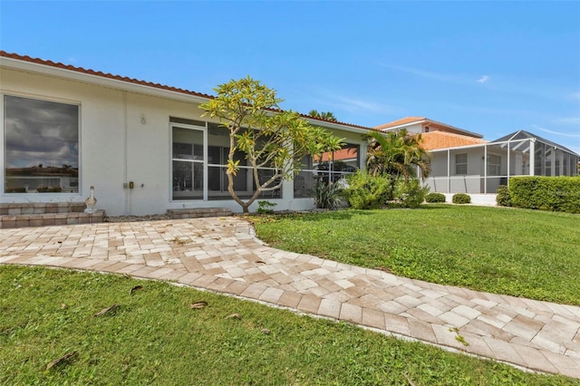 16 Tropicana Dr, Punta Gorda, FL 33950 - back of property with stucco siding, a lawn, and a patio area