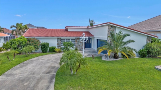 16 Tropicana Dr, Punta Gorda, FL 33950 - mediterranean / spanish house with a front lawn, a tiled roof, stone siding, driveway, and stucco siding