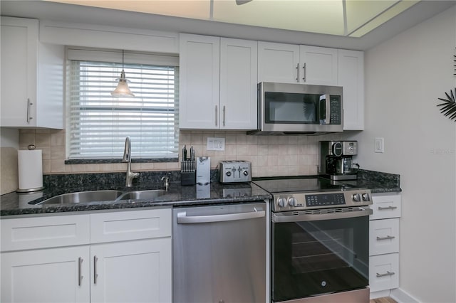 1080 Bal Harbor Blvd Unit 5B, Punta Gorda, FL 33950 - kitchen featuring stainless steel appliances, white cabinetry, dark stone counters, and backsplash
