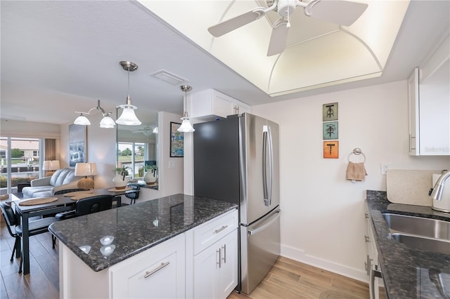 1080 Bal Harbor Blvd Unit 5B, Punta Gorda, FL 33950 - kitchen featuring a ceiling fan, light wood-type flooring, white cabinetry, freestanding refrigerator, and dark stone countertops