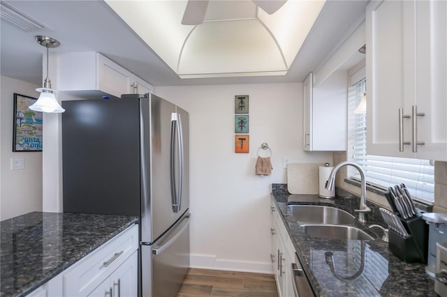 1080 Bal Harbor Blvd Unit 5B, Punta Gorda, FL 33950 - kitchen with white cabinets, stainless steel appliances, wood finished floors, hanging light fixtures, and dark stone counters