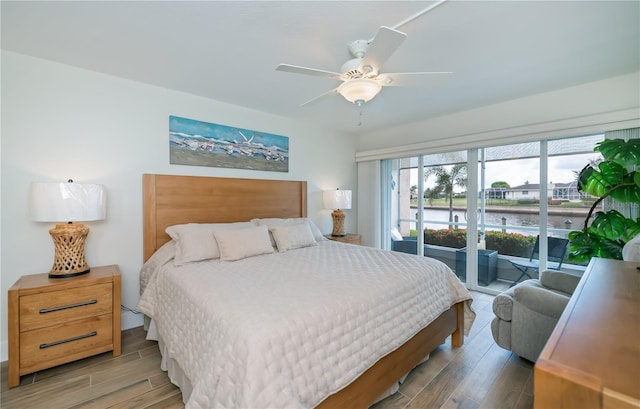 1080 Bal Harbor Blvd Unit 5B, Punta Gorda, FL 33950 - bedroom featuring wood finished floors, access to exterior, a water view, and ceiling fan
