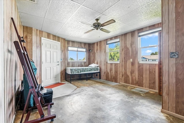 740 Dobell Ter NW, Port Charlotte, FL 33948 - living area featuring wooden walls, ceiling fan, concrete flooring, and a paneled ceiling