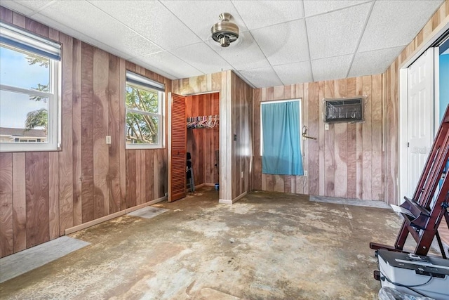 740 Dobell Ter NW, Port Charlotte, FL 33948 - empty room with wooden walls, a wall mounted air conditioner, and concrete floors