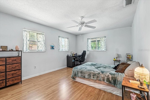 740 Dobell Ter NW, Port Charlotte, FL 33948 - bedroom featuring wood finished floors, a textured ceiling, a ceiling fan, and a desk