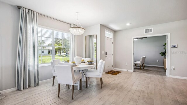 2047 Royal Tern Cir, Punta Gorda, FL 33983 - dining space with light wood finished floors and a chandelier