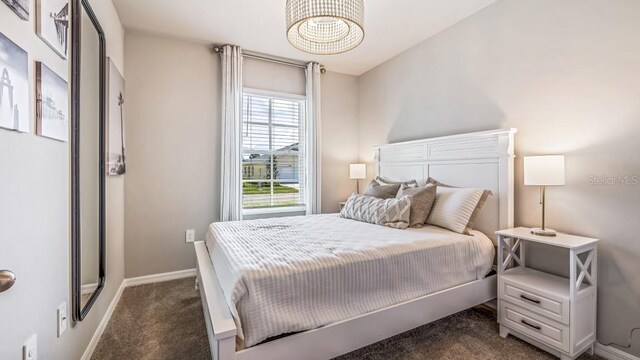 2047 Royal Tern Cir, Punta Gorda, FL 33983 - bedroom with dark colored carpet and a chandelier