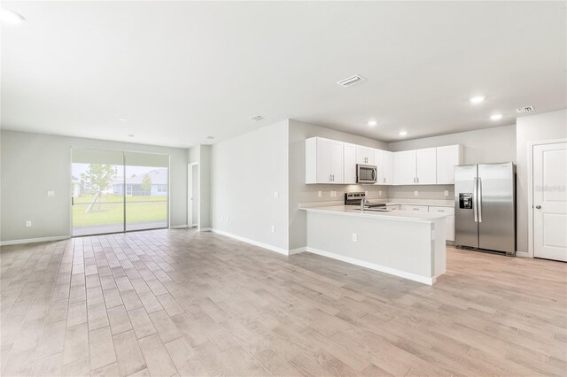 2047 Royal Tern Cir, Punta Gorda, FL 33983 - kitchen featuring appliances with stainless steel finishes, open floor plan, light countertops, light wood finished floors, and recessed lighting