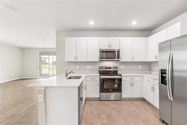 2047 Royal Tern Cir, Punta Gorda, FL 33983 - kitchen featuring appliances with stainless steel finishes, a peninsula, light wood finished floors, light countertops, and recessed lighting