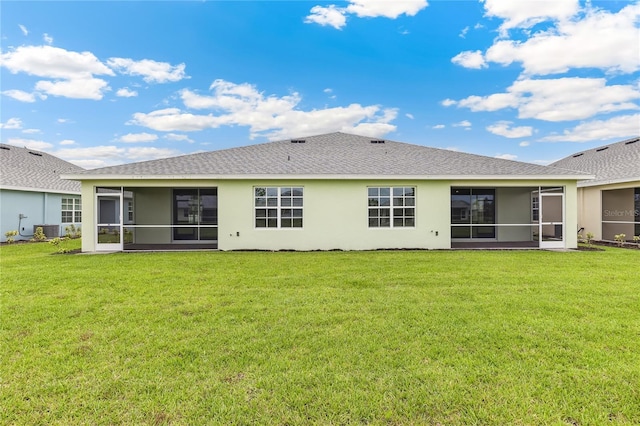 2047 Royal Tern Cir, Punta Gorda, FL 33983 - rear view of house featuring a sunroom, stucco siding, a yard, and a shingled roof