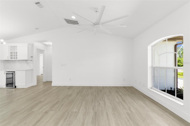 2399 Redstone Ave, North Port, FL 34288 - unfurnished living room featuring lofted ceiling, beverage cooler, light wood-type flooring, a dry bar, and ceiling fan