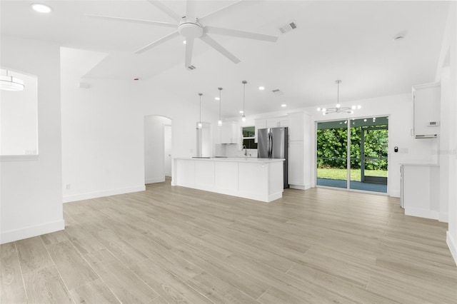 2399 Redstone Ave, North Port, FL 34288 - unfurnished living room featuring arched walkways, light wood finished floors, a chandelier, ceiling fan, and vaulted ceiling