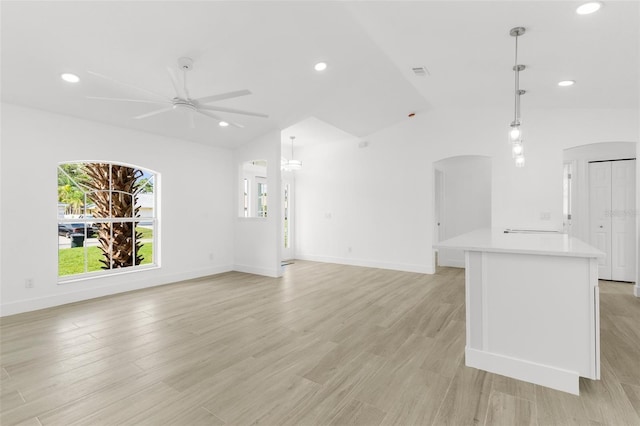 2399 Redstone Ave, North Port, FL 34288 - unfurnished living room with arched walkways, vaulted ceiling, a ceiling fan, recessed lighting, and light wood finished floors
