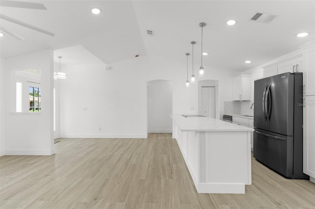 2399 Redstone Ave, North Port, FL 34288 - kitchen featuring appliances with stainless steel finishes, vaulted ceiling, arched walkways, light countertops, and white cabinetry