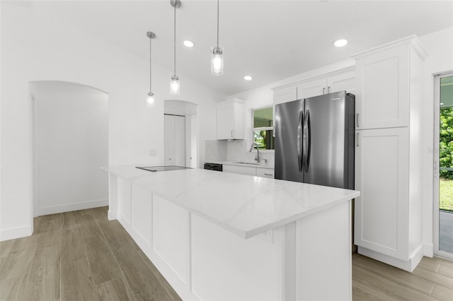 2399 Redstone Ave, North Port, FL 34288 - kitchen with freestanding refrigerator, arched walkways, white cabinets, light wood-type flooring, and recessed lighting