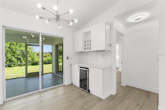 2399 Redstone Ave, North Port, FL 34288 - indoor dry bar with beverage cooler, light wood-style floors, a chandelier, lofted ceiling, and decorative backsplash