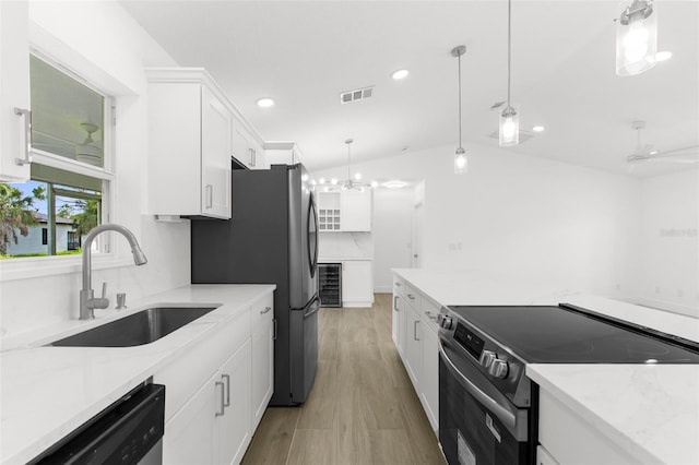 2399 Redstone Ave, North Port, FL 34288 - kitchen with appliances with stainless steel finishes, white cabinets, recessed lighting, lofted ceiling, and pendant lighting